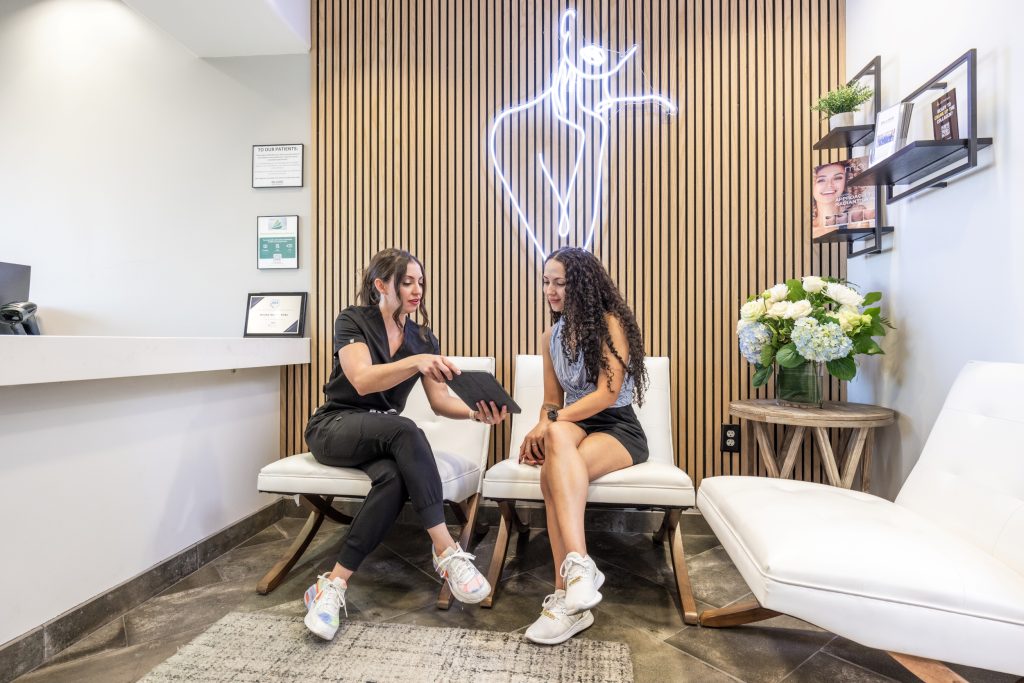 MedSpa provider showing treatment plan to client during consultation, highlighting personalized care in a professional aesthetic clinic setting.