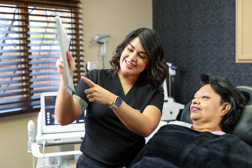 MedSpa provider showing treatment plan to client during consultation, highlighting personalized care in a professional aesthetic clinic setting.