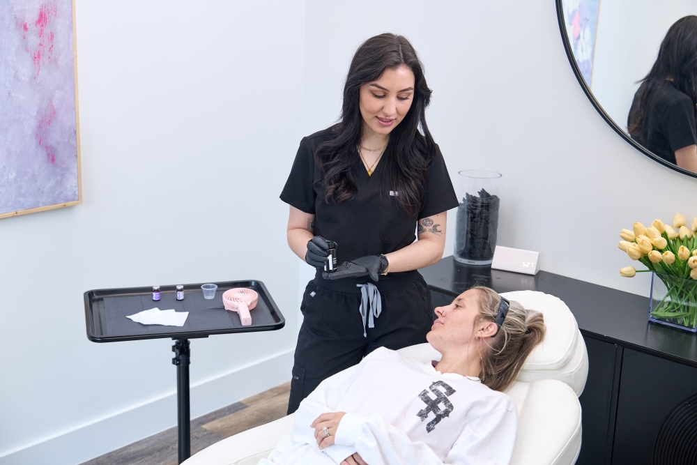 MedSpa provider preparing injectable treatment while consulting with a relaxed client in a modern aesthetic clinic, emphasizing personalized cosmetic care and trust-building patient interaction.