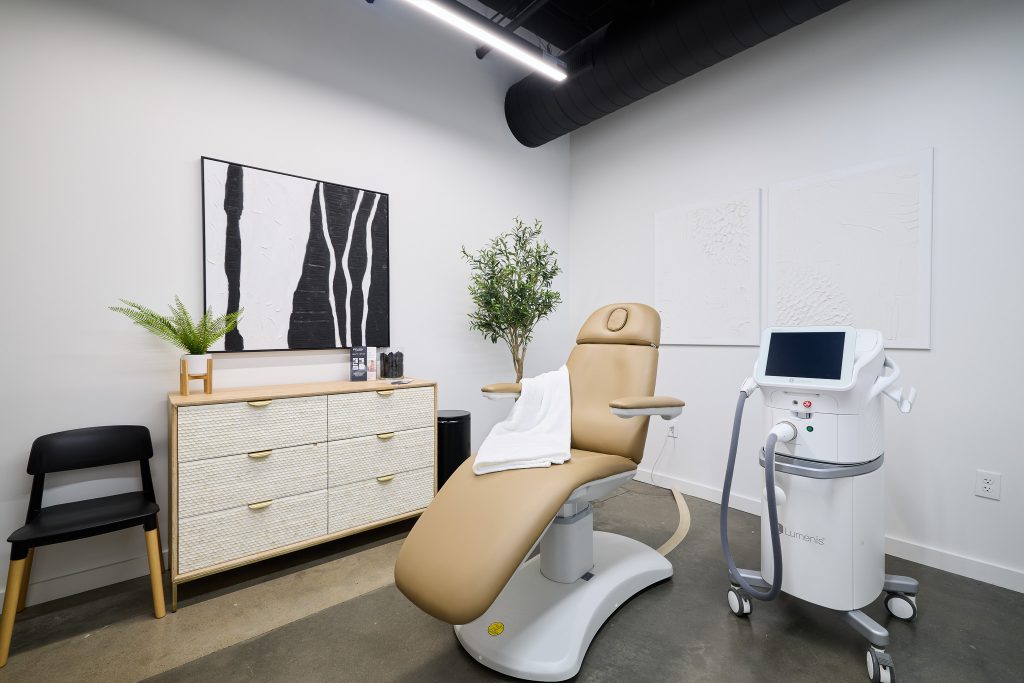 Contemporary MedSpa treatment room featuring neutral MedSpa decor, botanical elements, and cutting-edge aesthetic equipment.